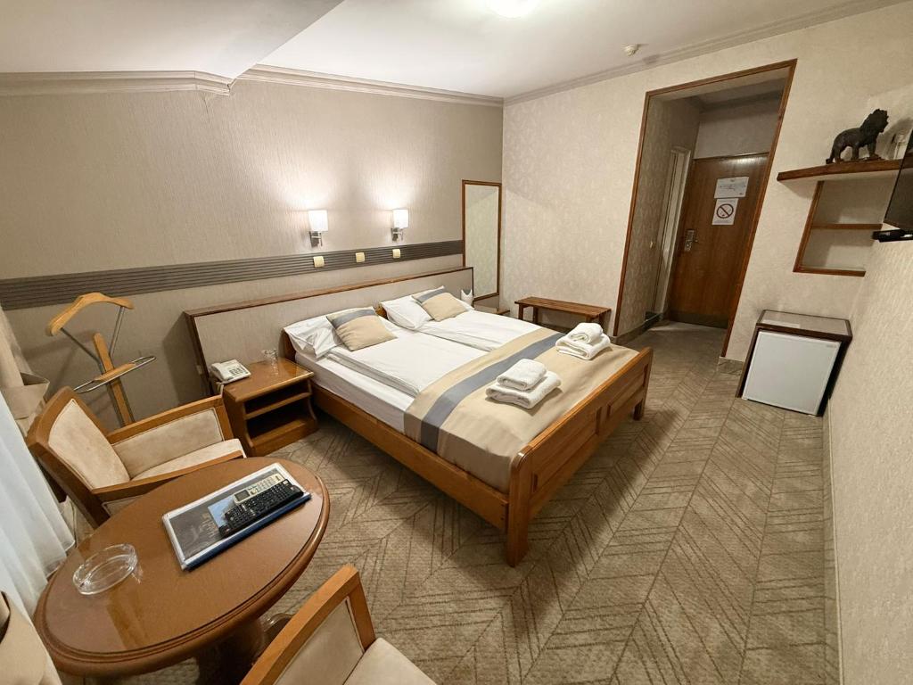 a hotel room with a bed and a table at Garni Hotel Lav in Belgrade