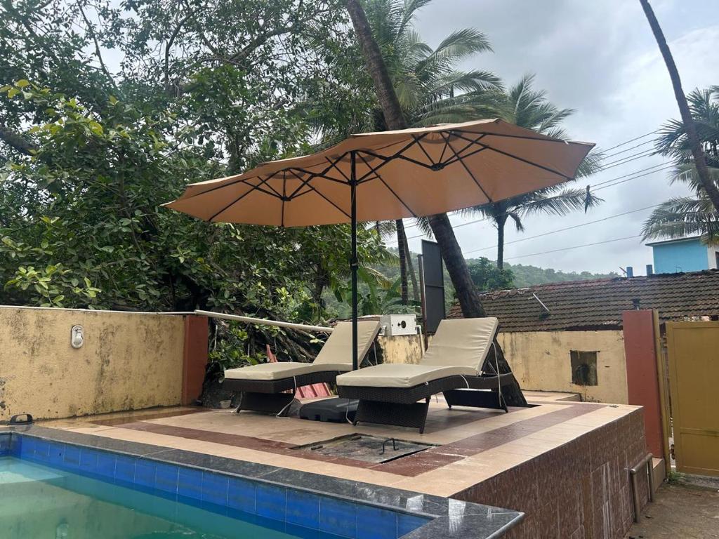 a patio with an umbrella next to a pool at SAHAY VILLA RESORT in Durbate