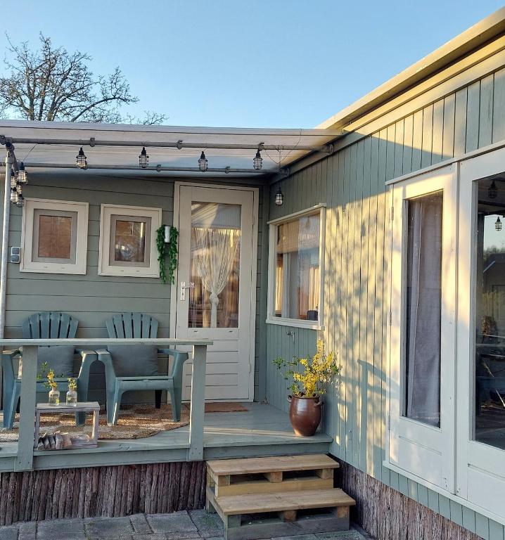 a porch of a house with a table and chairs at Knus Tiny house 2 pers rust natuur en privacy in Borger