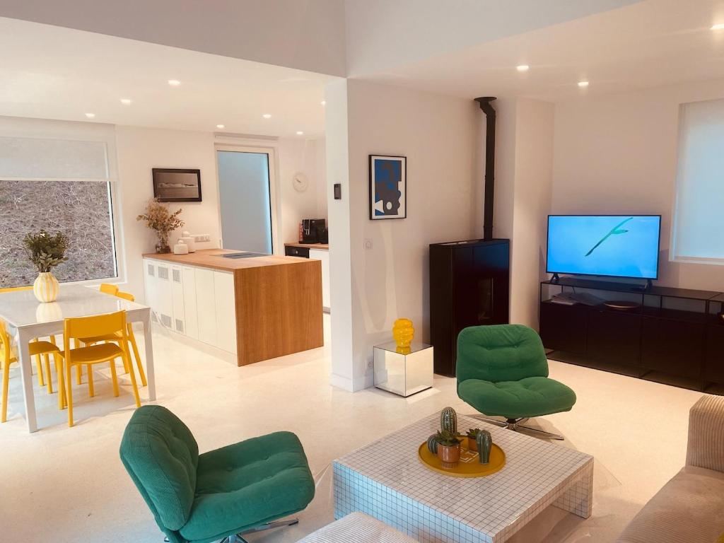 a living room with green chairs and a flat screen tv at Villa la Hune- Proche Golfs & Plage in Neufchâtel-Hardelot