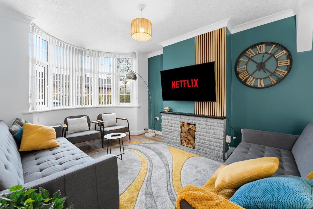a living room with a couch and a clock on the wall at Delves House in Bescot