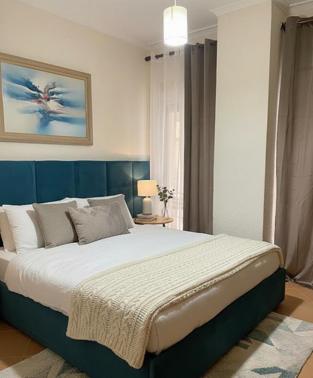 a bedroom with a large bed with a blue headboard at Hotel Ibiza in Golem