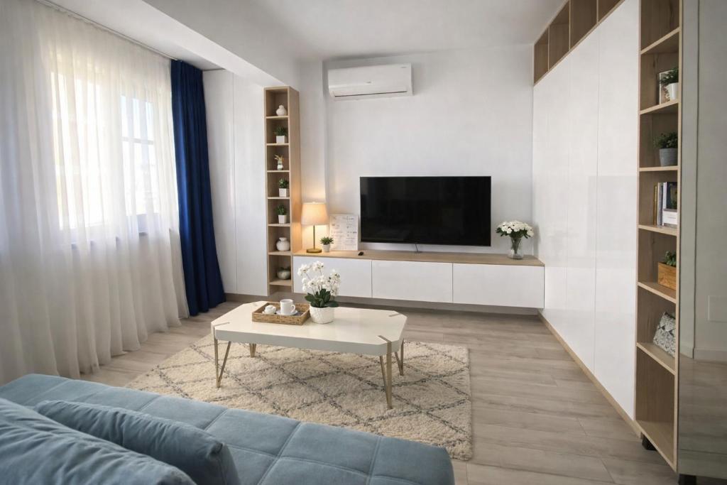 a living room with a blue couch and a tv at Zen studio near Mall Moldova in Iaşi