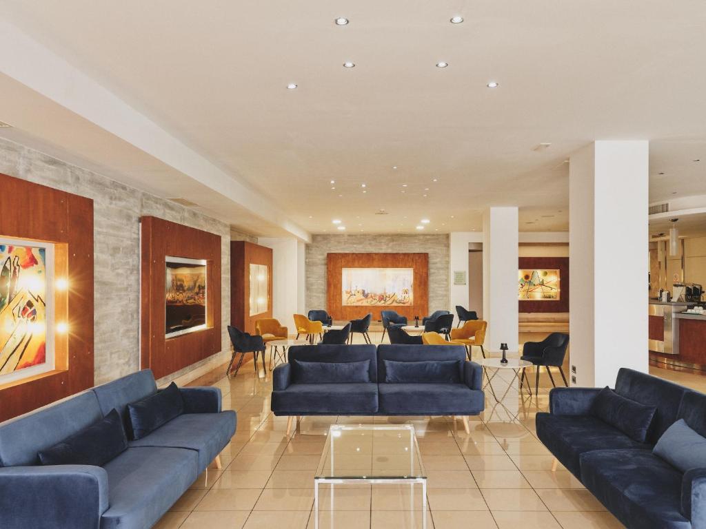 a living room with blue couches and chairs at Hotel Planet International in Arezzo