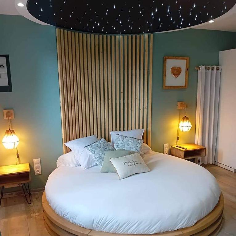 a bedroom with a large bed with two pillows on it at Au Spa d'eau pâle in Ferques