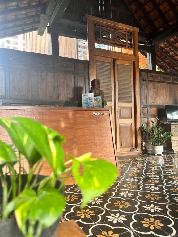 a room with a counter and a floor with plants at PaddyView Hostel in Banyuwangi