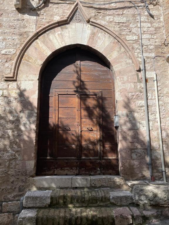 a large wooden door in a brick building at Arcangelo SUITE in Assisi