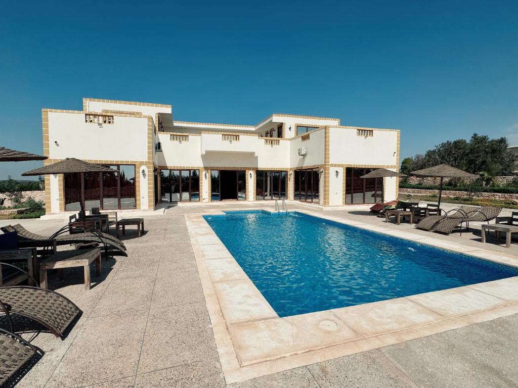 a resort with a swimming pool in front of a building at RyadIbou in Essaouira
