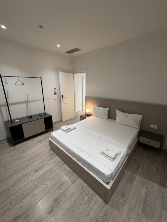 a bedroom with a large white bed and a mirror at Leon Hotel in Kashari