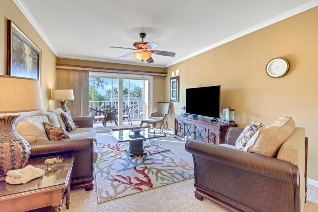 a living room with furniture and a flat screen tv at Palm Beach Landings A107 in Fort Myers