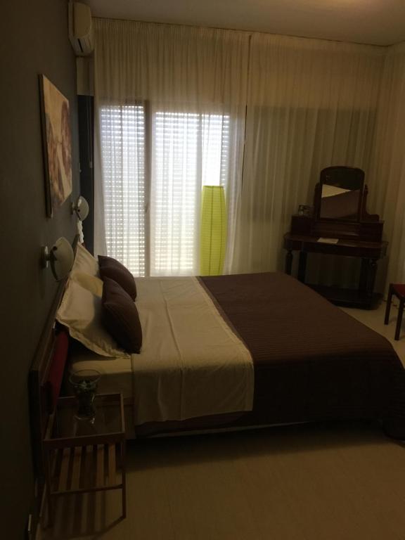 阿普里利亞的住宿－Hotel San Michele，一间卧室设有一张大床和一个窗户。