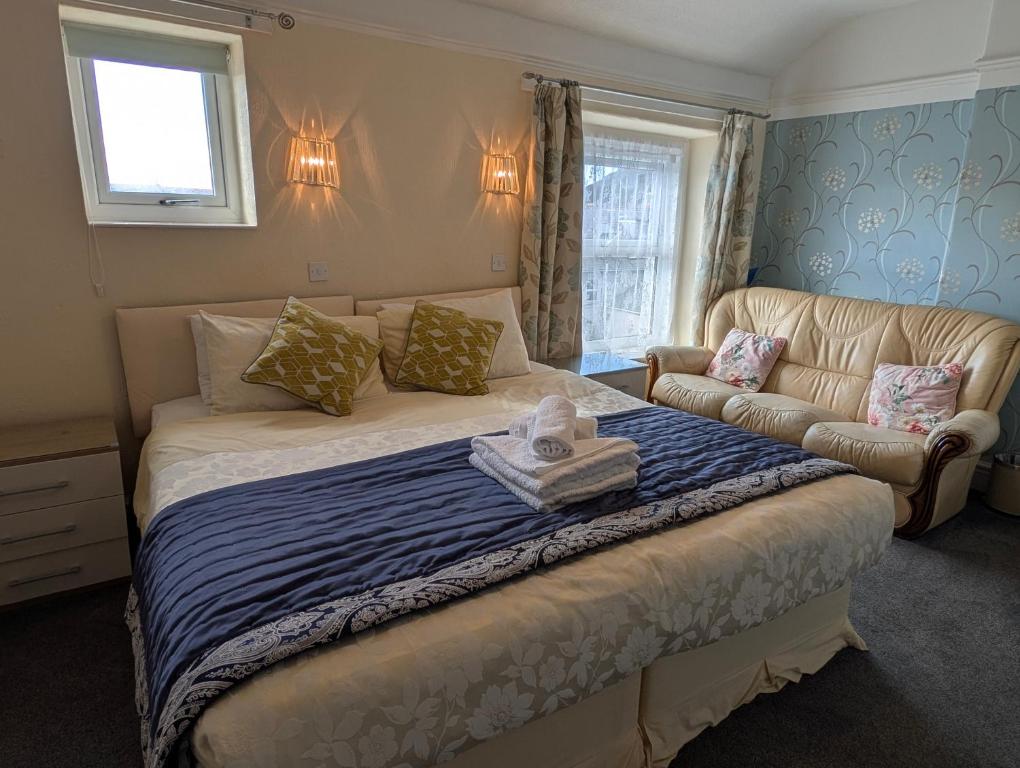 a small bedroom with a bed and a couch at Del Mar in Llandudno