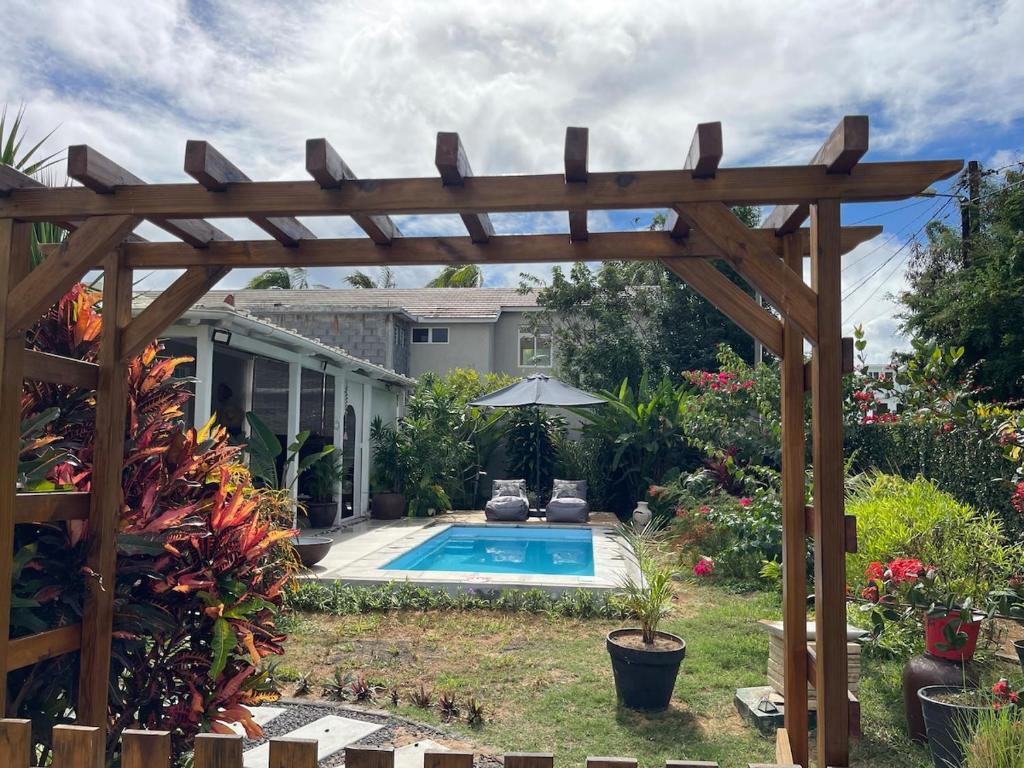a wooden pergola next to a swimming pool at Villa Evalia in Albion