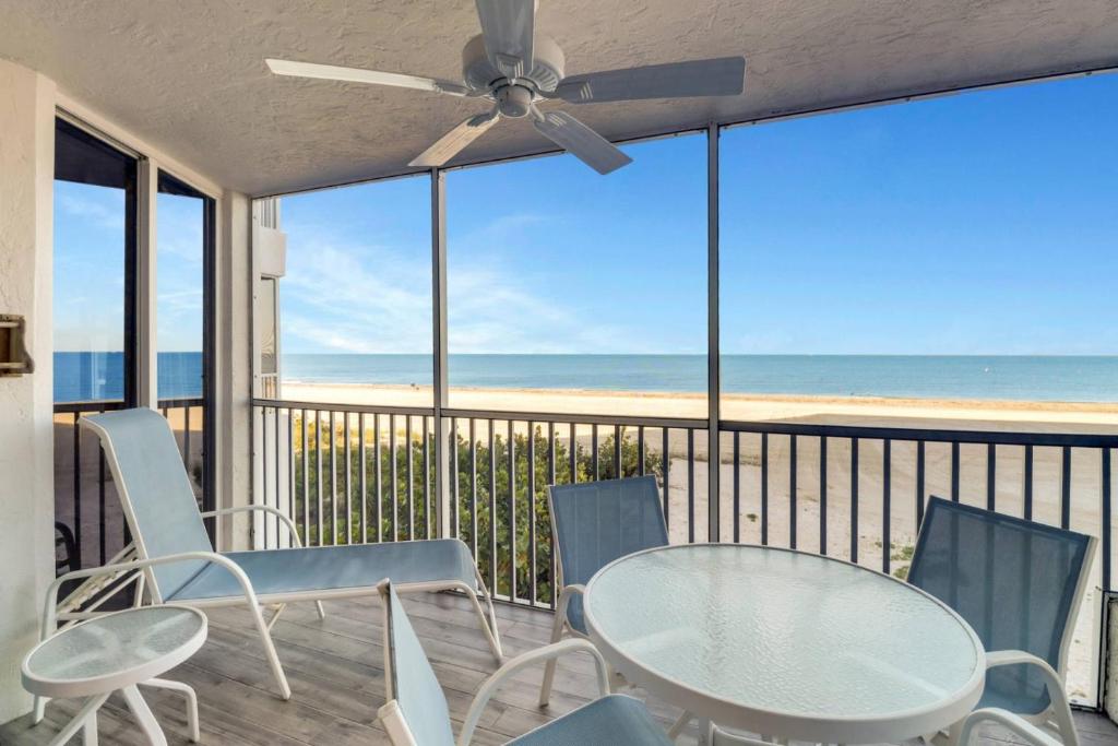 a table and chairs on a balcony with a view of the beach at Estero Island Beach Villas 105 in Fort Myers Beach