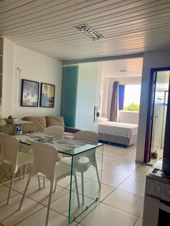 a living room with a glass table and chairs at Flat Bela Amarração in Luis Correia