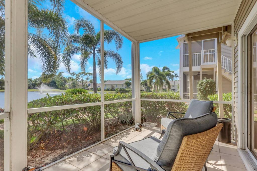 a screened porch with a view of the ocean and palm trees at 4111 Gunnison Ct #1214 in Estero