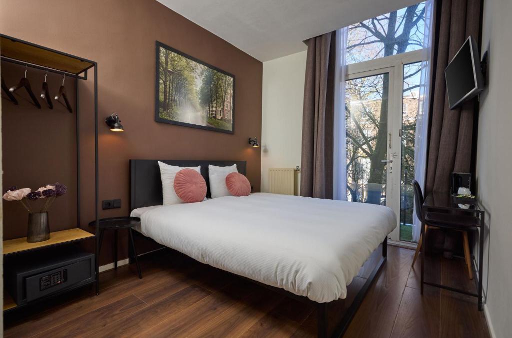 a bedroom with a large bed and a window at Quentin Museum Square Hotel in Amsterdam