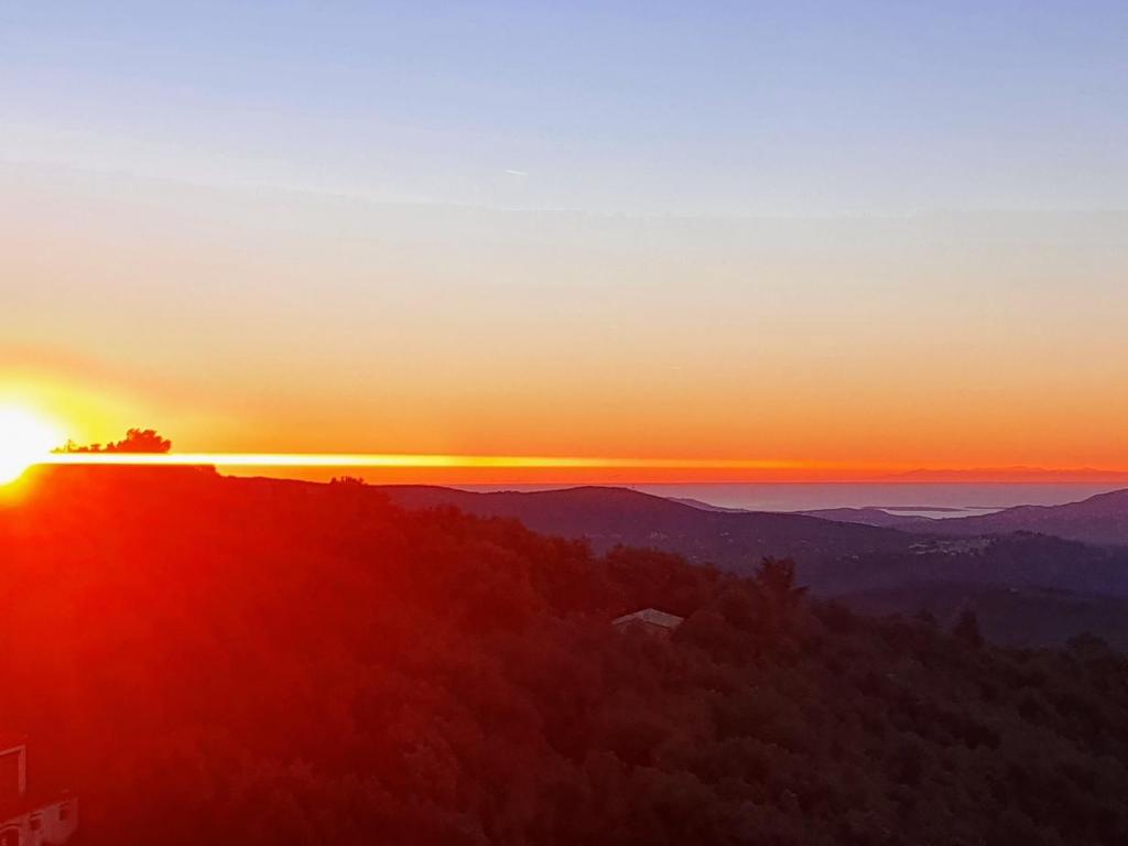 a sunset from the top of a mountain with a tree at La Catounière - Maison de village avec magnifique vue in Mons