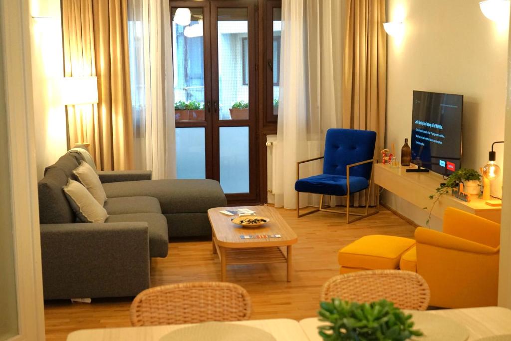 a living room with a couch and a tv at Spacious 3BR, 2BT with 5 balconies in Bucharest
