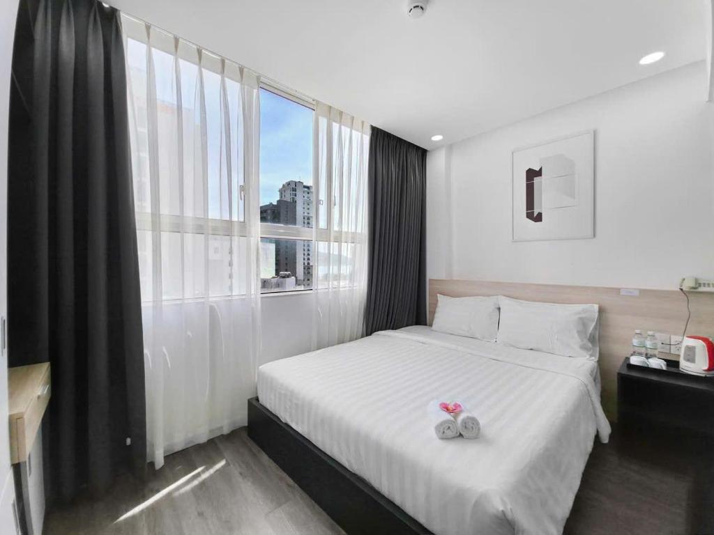 a bedroom with a bed and a large window at Moana Hotel Nha Trang in Nha Trang