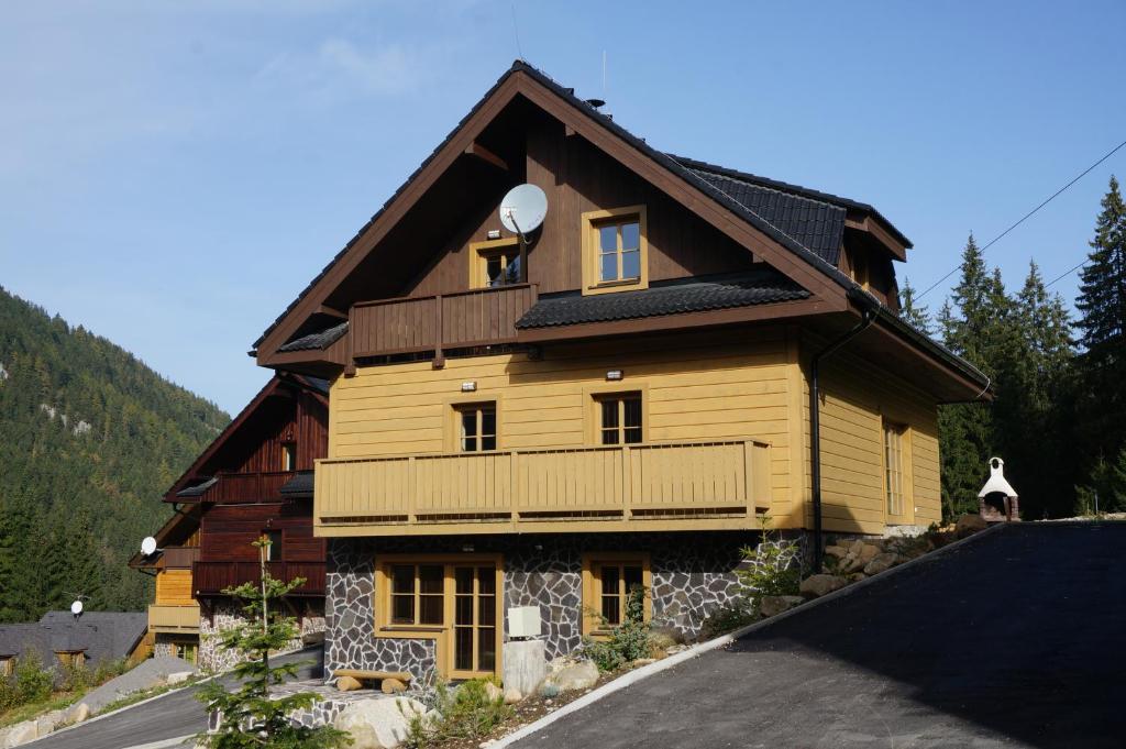 una grande casa in legno con balcone su una strada di Chata Bajana a Demänovská Dolina