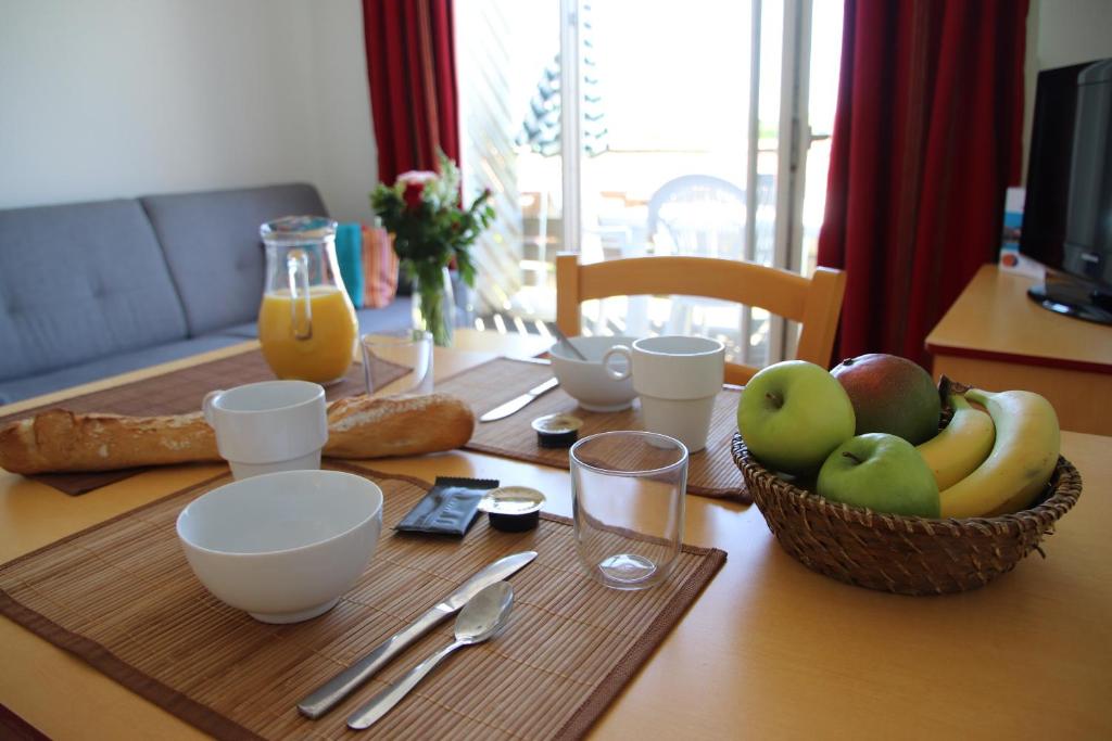 a wooden table with a bowl of fruit on it at Oly Vacances Les Landes in Cassen