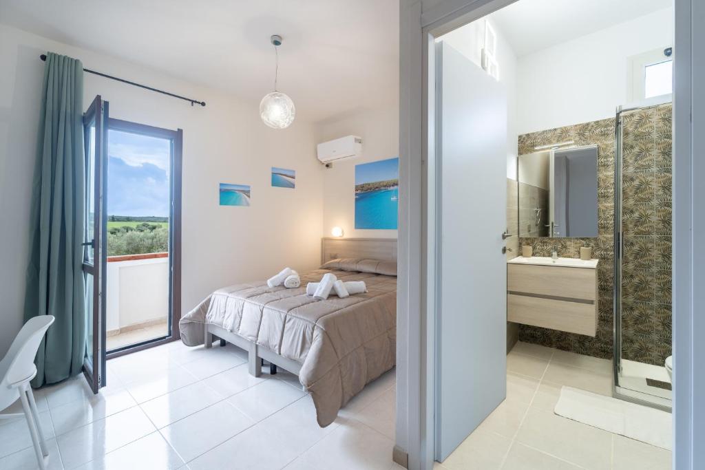 a bedroom with a bed and a bathroom at Via del Mare in Giba