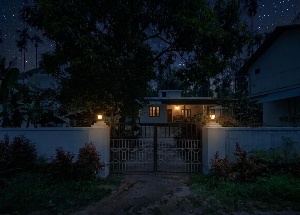 a house with a gate at night with lights at Villa 9 degrees north in Sultan Bathery