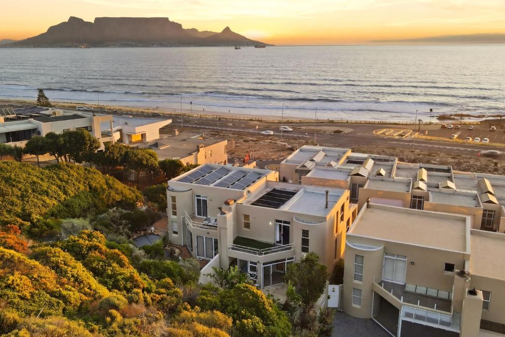 an aerial view of houses and the beach at sunset at White Waters in Cape Town