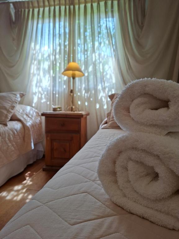a white bed with a bunch of towels on it at Hotel El Descanso in Junín