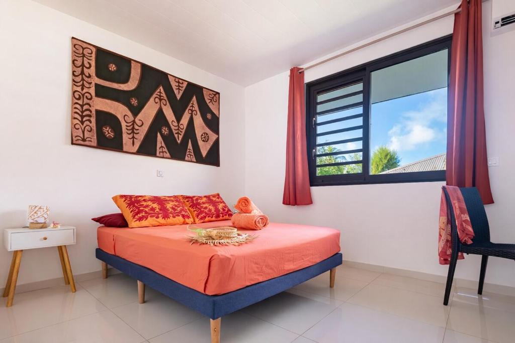 a bedroom with a bed and a window at Moorea bungalow cosy proche plage de Temae in Moorea