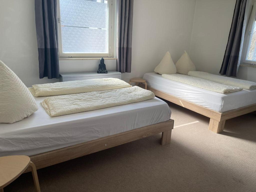 two twin beds in a room with a window at Easy Stay Valencia in Oberboihingen