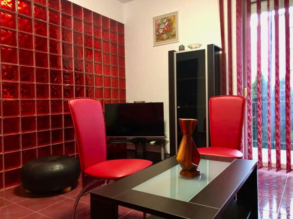 a living room with two red chairs and a table at Joy City Stay Calea Timisoarei 4 in Timişoara