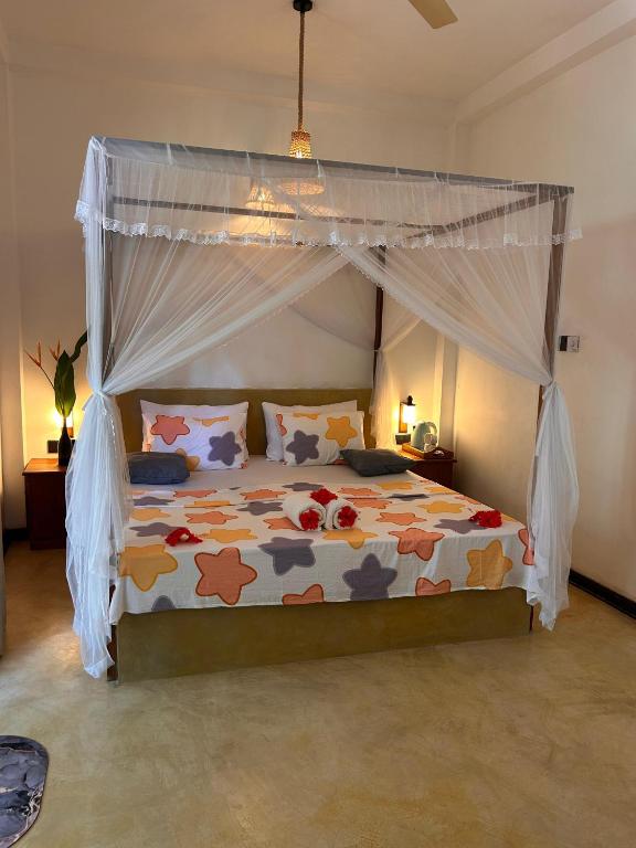 a bedroom with a bed with a canopy at LotusScape Ahangama in Ahangama