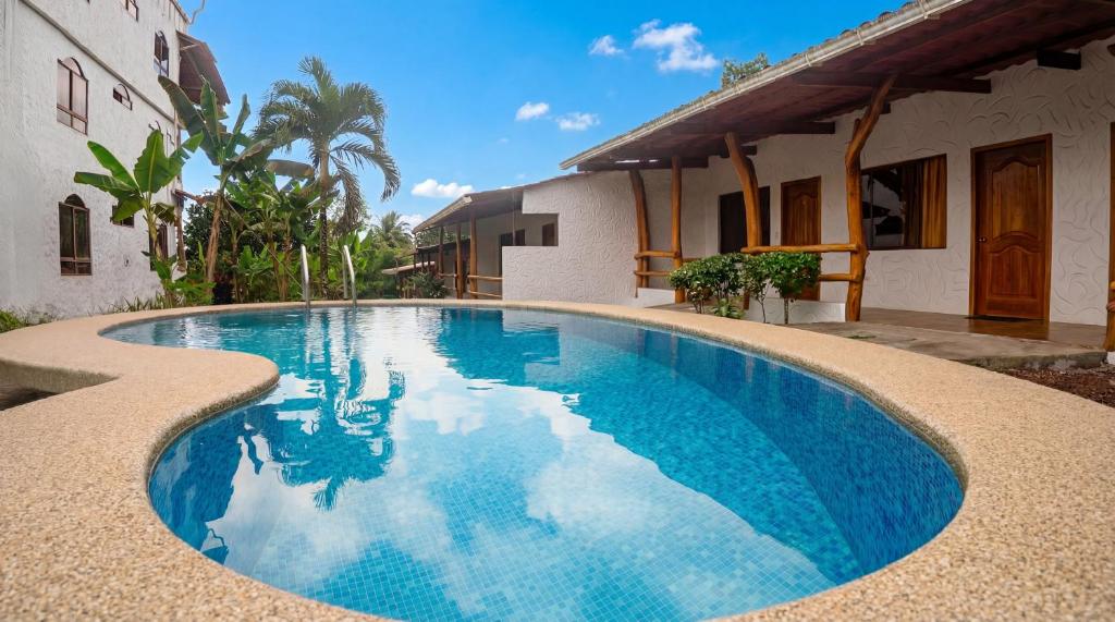 a swimming pool in front of a house at Hotel Twin Galápagos in Puerto Ayora