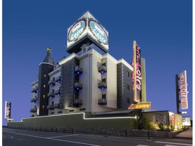 a large building with a clock on top of it at ホテルロアール 大人専用 in Miyake