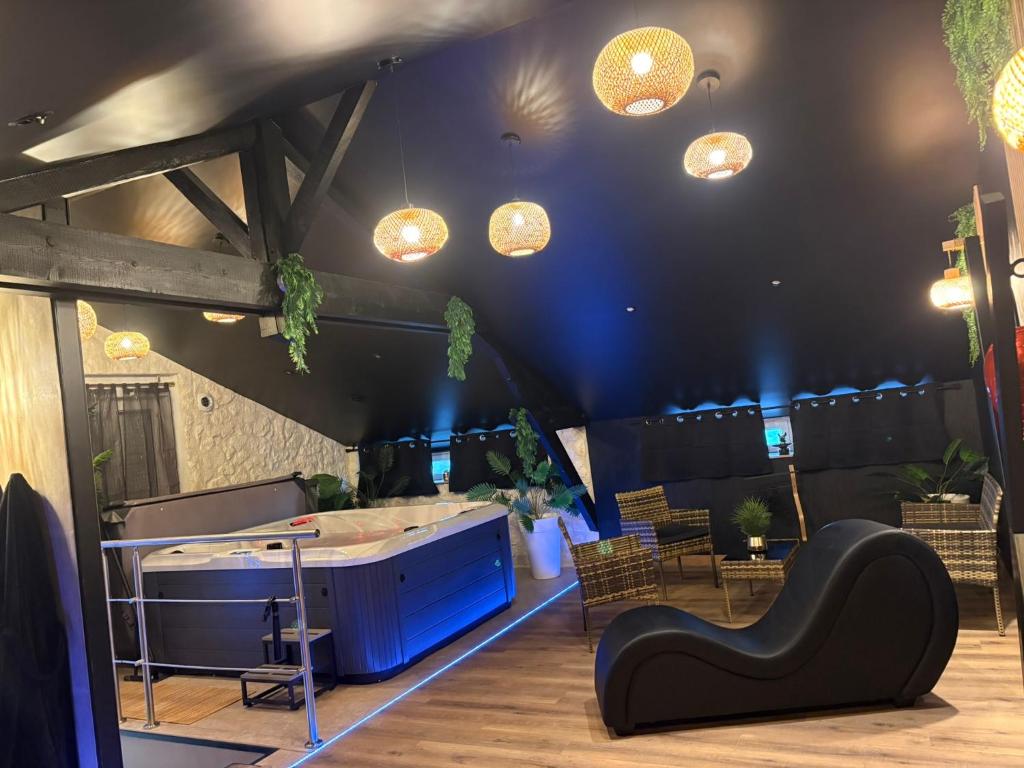 a room with a table and some lights on the ceiling at AMORE suite de luxe & spa in Laplume