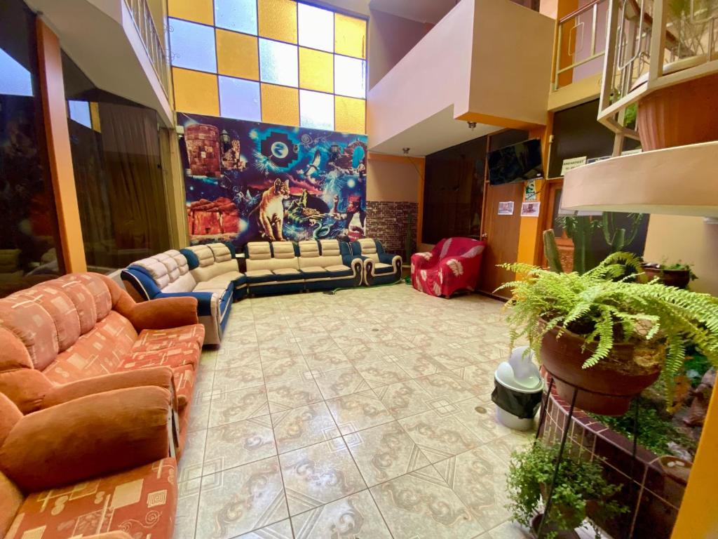 a living room with couches and a painting on the wall at Nayras Puno Hotel in Puno