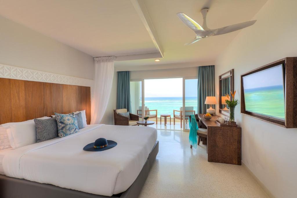 a hotel room with a bed and a living room at Diamonds Leisure Beach & Golf Resort in Diani Beach