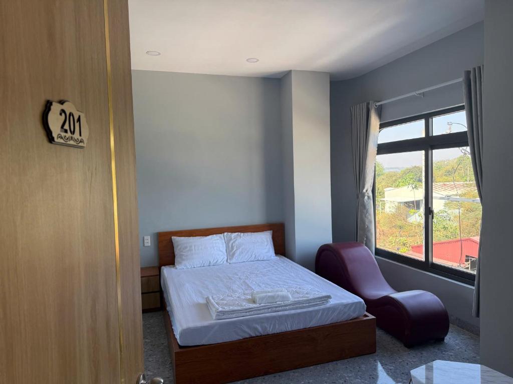 a bedroom with a bed and a chair and a window at Hotel Trần Anh in Xóm Bên Ðông