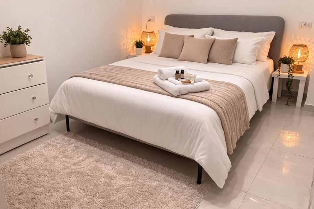 a bedroom with a large bed with a towel on it at Romy boutique netanya in Netanya