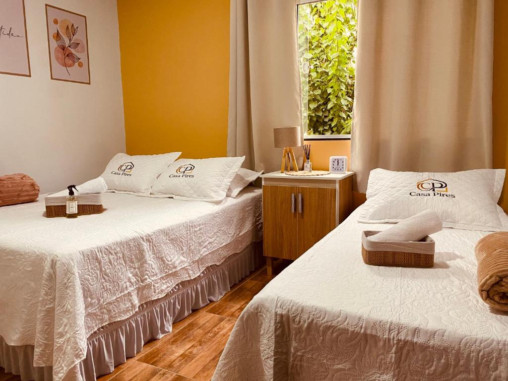 a bedroom with two beds and a window at Casa Pires - Sinop MT in Sinop