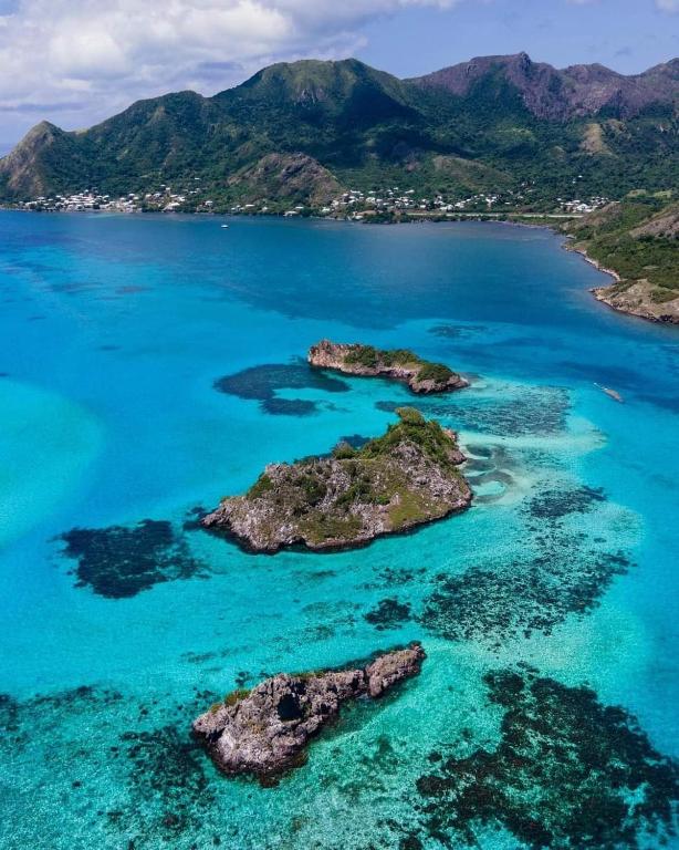 eine Insel im Ozean mit blauem Wasser und Felsen in der Unterkunft Posada Cedar Valley in Providencia