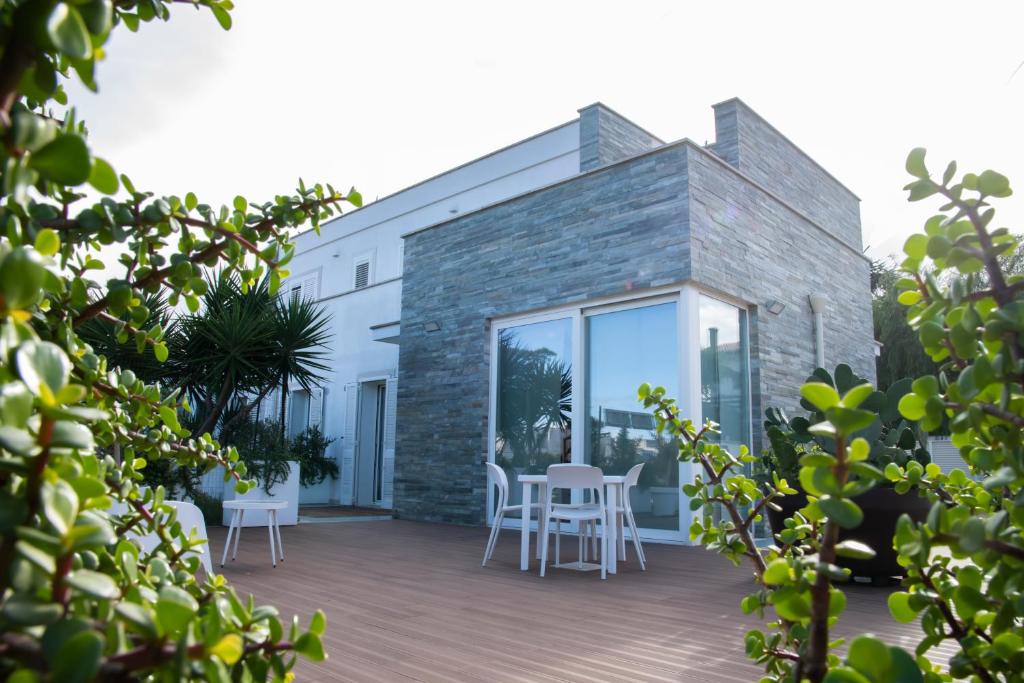 a patio with white chairs and tables on a building at Borgo Dei Cedri in Bari