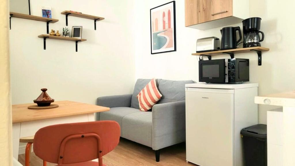 a living room with a couch and a microwave at ZenDay studio proche de Paris in Ivry-sur-Seine