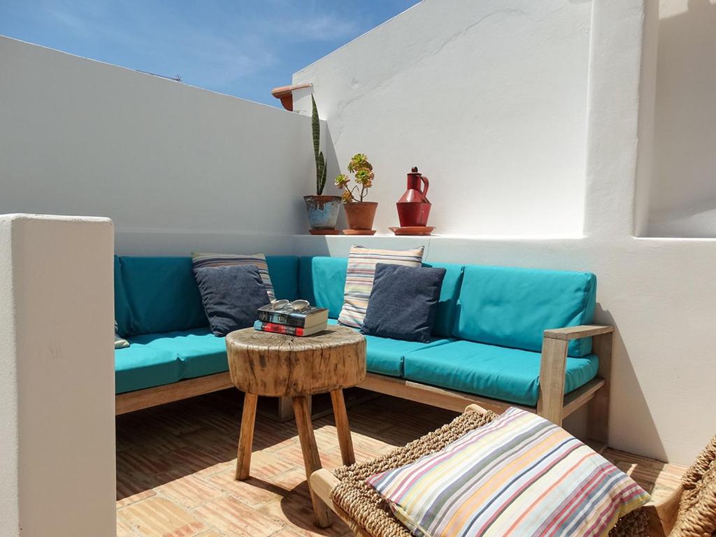 a living room with a blue couch and a table at Casa Nela in Odeceixe