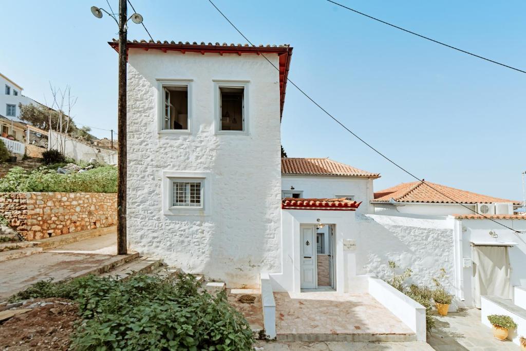 a white house with a red roof at Earino apartments in Hydra