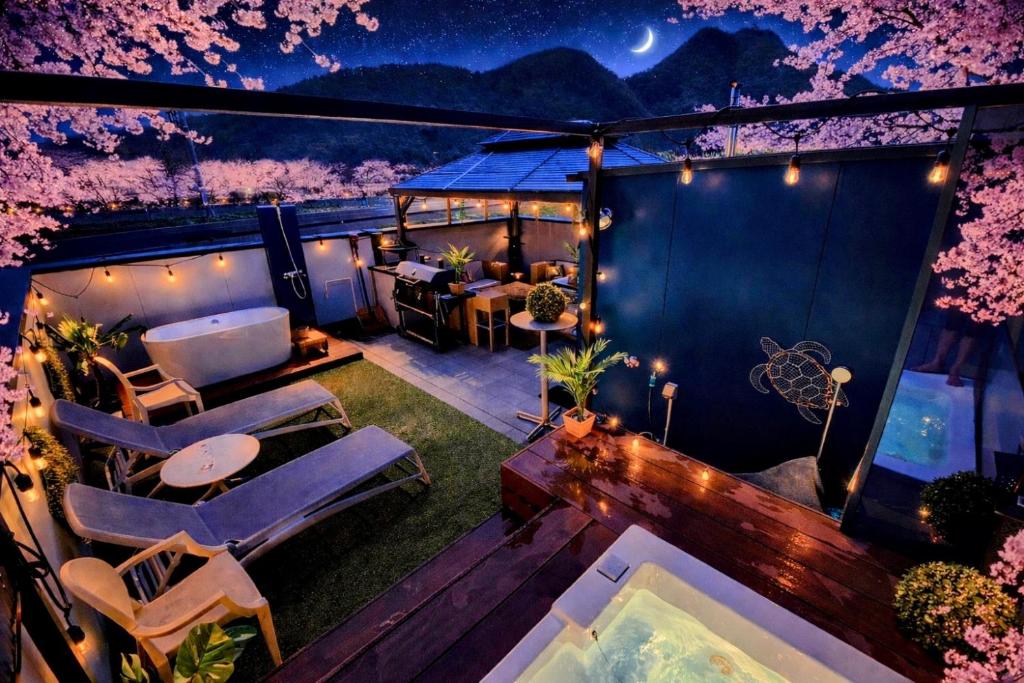 a balcony with chairs and a table and trees at Vacanza gifu sauna villa in Gifu