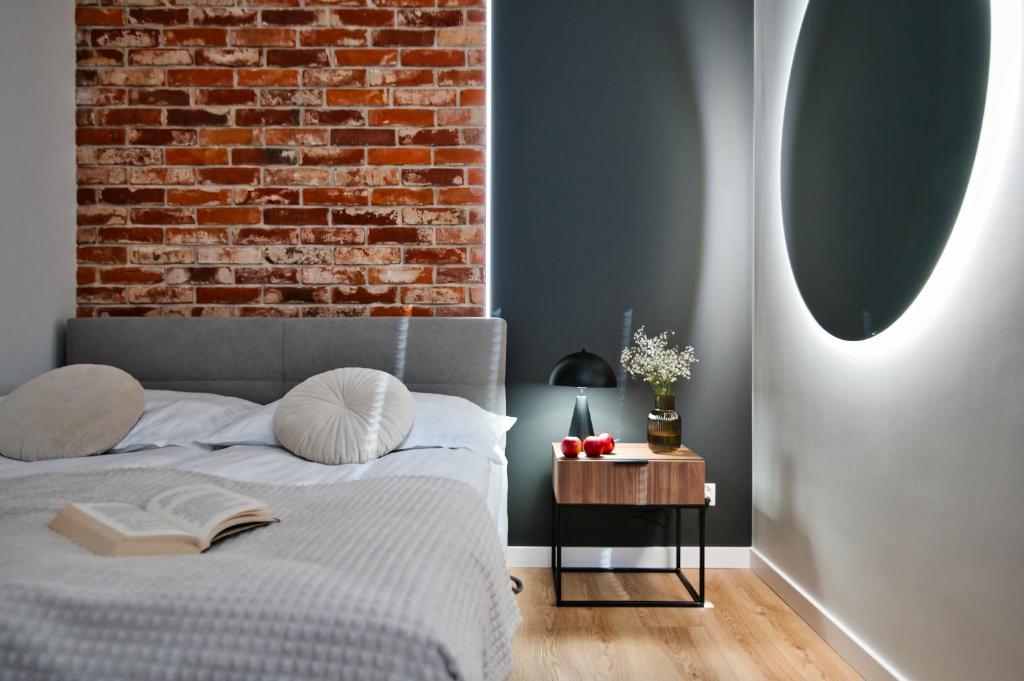 a bedroom with a bed and a brick wall at Calma - apartamenty z ogrodem blisko Energylandii in Zator
