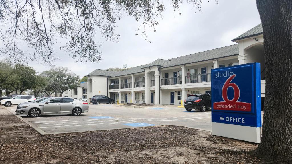 a sign in front of a building with cars parked at Studio 6-Houston, TX - Hobby South in Houston